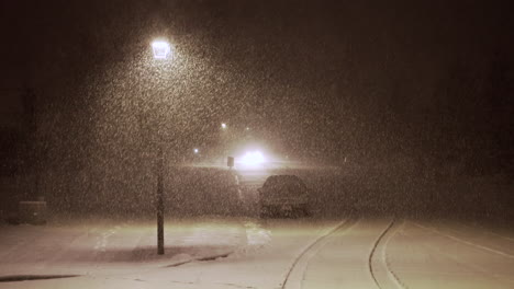 car driving as heavy snow falls on street