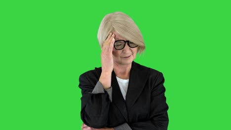 una mujer anciana de cabello gris con ropa formal sufriendo de dolor de cabeza en una pantalla verde, llave de croma