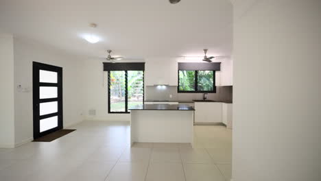 open kitchen with black stone island bench top with white cupboards