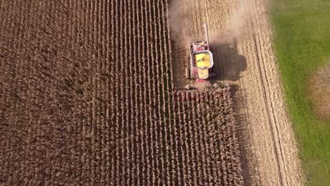 vista de pájaro de la cosechadora en acción, cosechando maíz en el sureste de michigan - toma aérea de drones