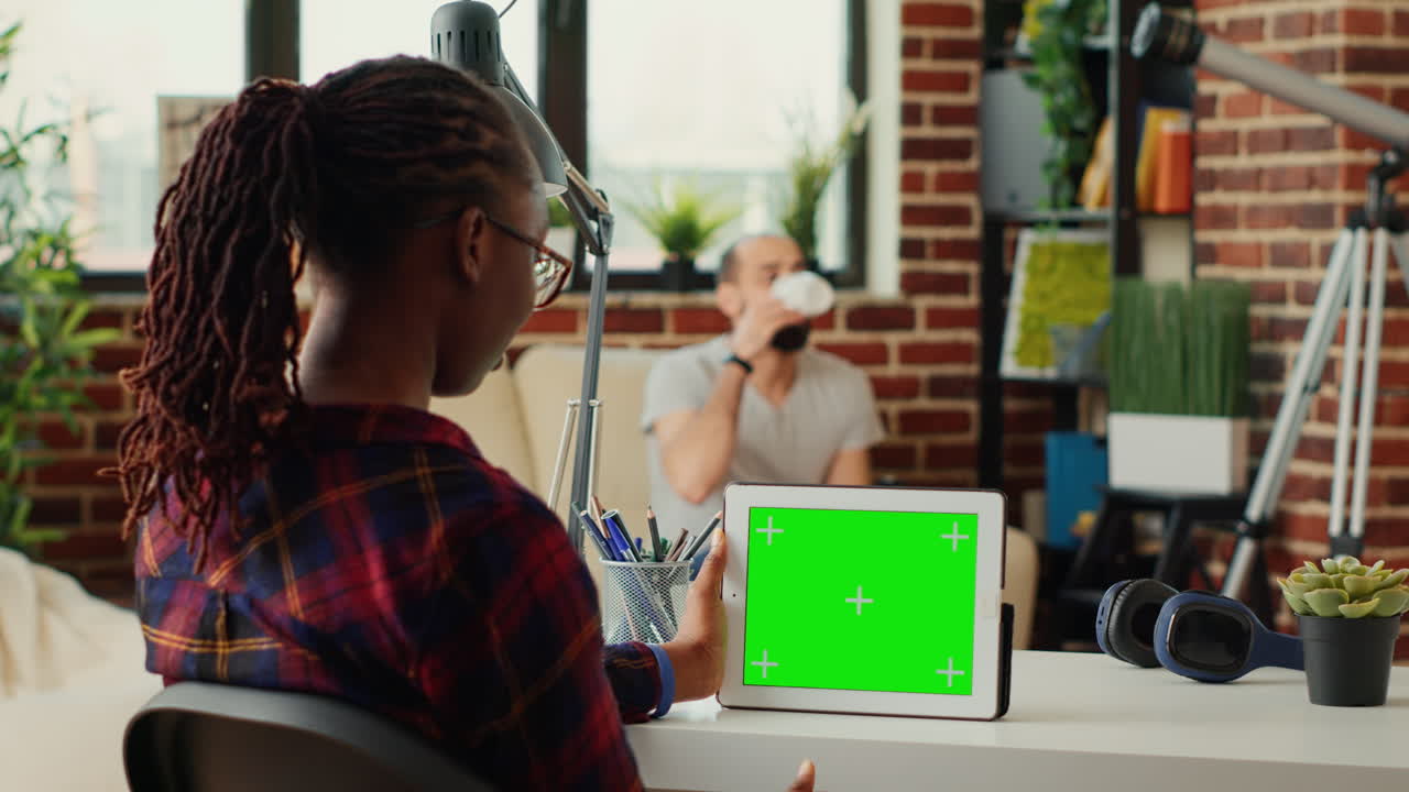 Young entrepreneur using digital tablet with horizontal greenscreen