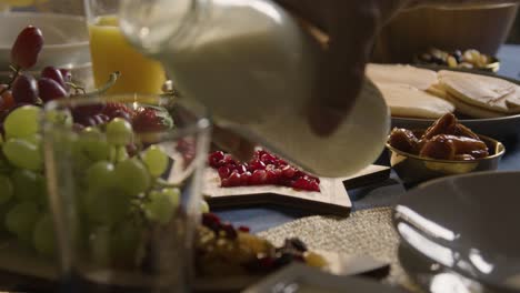 muslim family table at home set for iftar meal breaking daily fast during ramadan with milk being poured