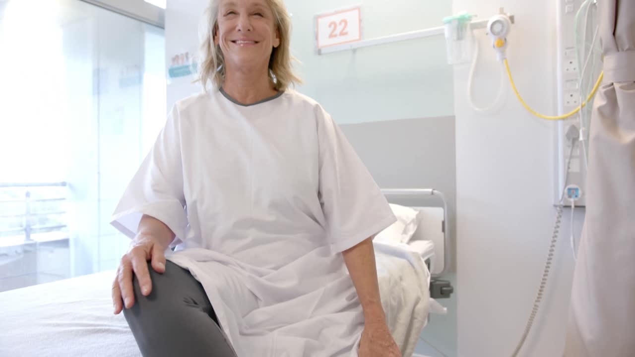 retrato de una paciente mayor caucásica feliz con una pierna protésica sentada en la cama del hospital