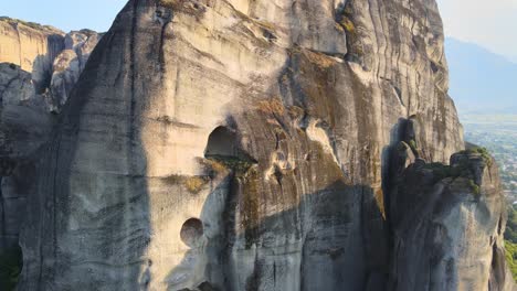 acercándose a una pequeña cueva natural en meteora, grecia con un dron, aéreo