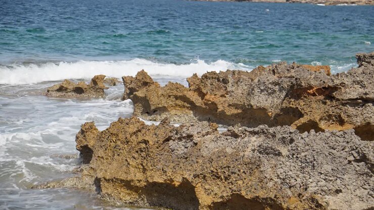 Spiaggia rocciosa lambita da piccole onde del Mar delle Baleari, Isola di Maiorca, Spagna.