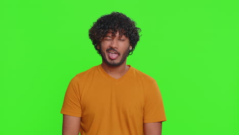 comical funny indian man making playful silly facial expressions fooling around showing tongue
