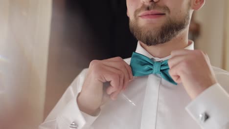 Groom-adjusts-bow-tie.-Preparing-to-go-to-the-bride.-Businessman.-Wedding-day