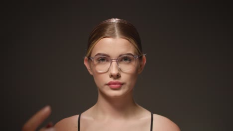 smart young female student adjusts her glasses, concept thinking, gets an idea