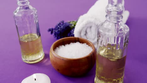 Sea-salt-in-wooden-bowl,-towel,-oil,-candle-and-flowers