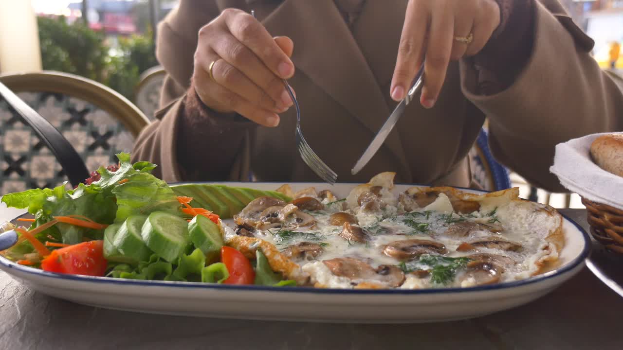 Close-up of Person Eating Mushroom Omelet with Salad