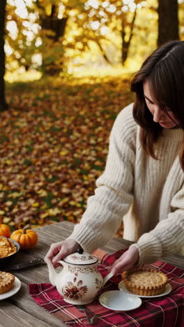 autumn tea party with a woman, teapot, and pie outdoors