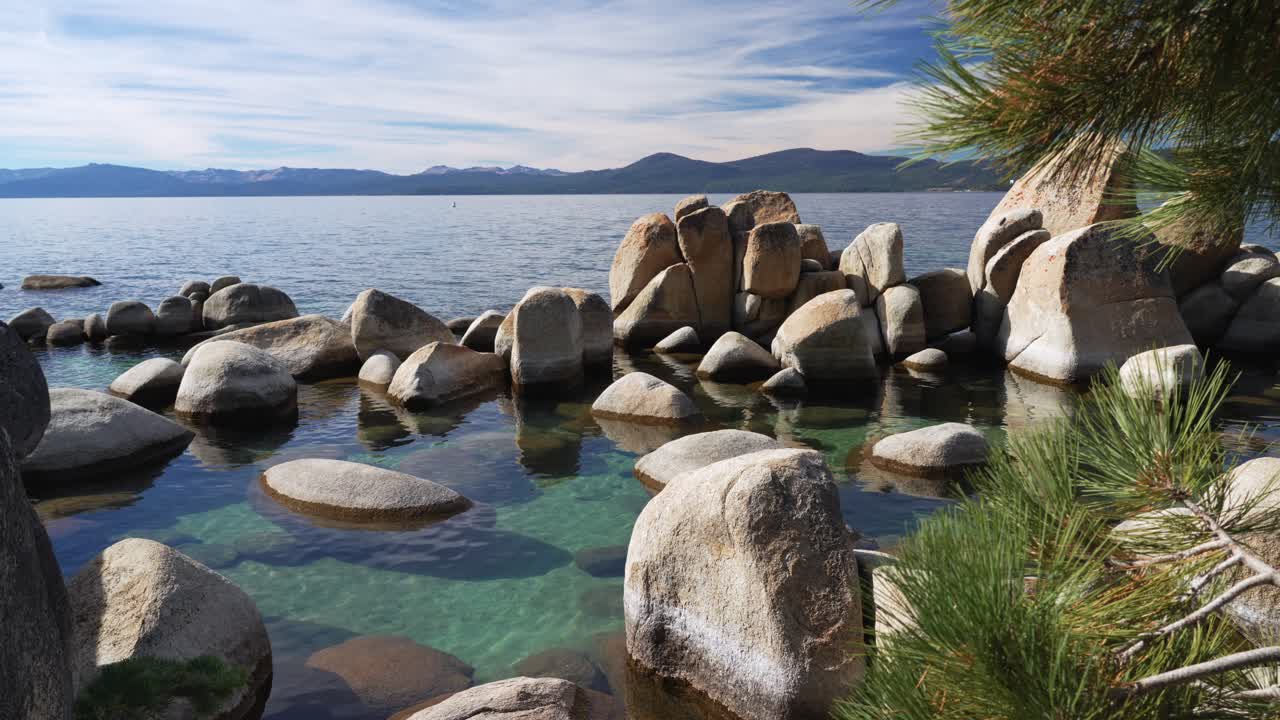 Fridfull strandlinje vid Lake Tahoe med klart vatten och släta granitblock