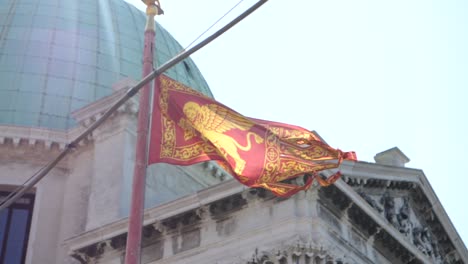 flag blowing in breeze with church in background