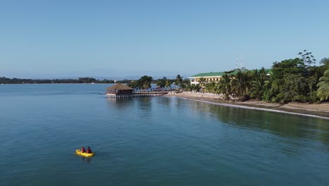 panama aerial: kayakers paddle at playa tortuga with hotel resort dock