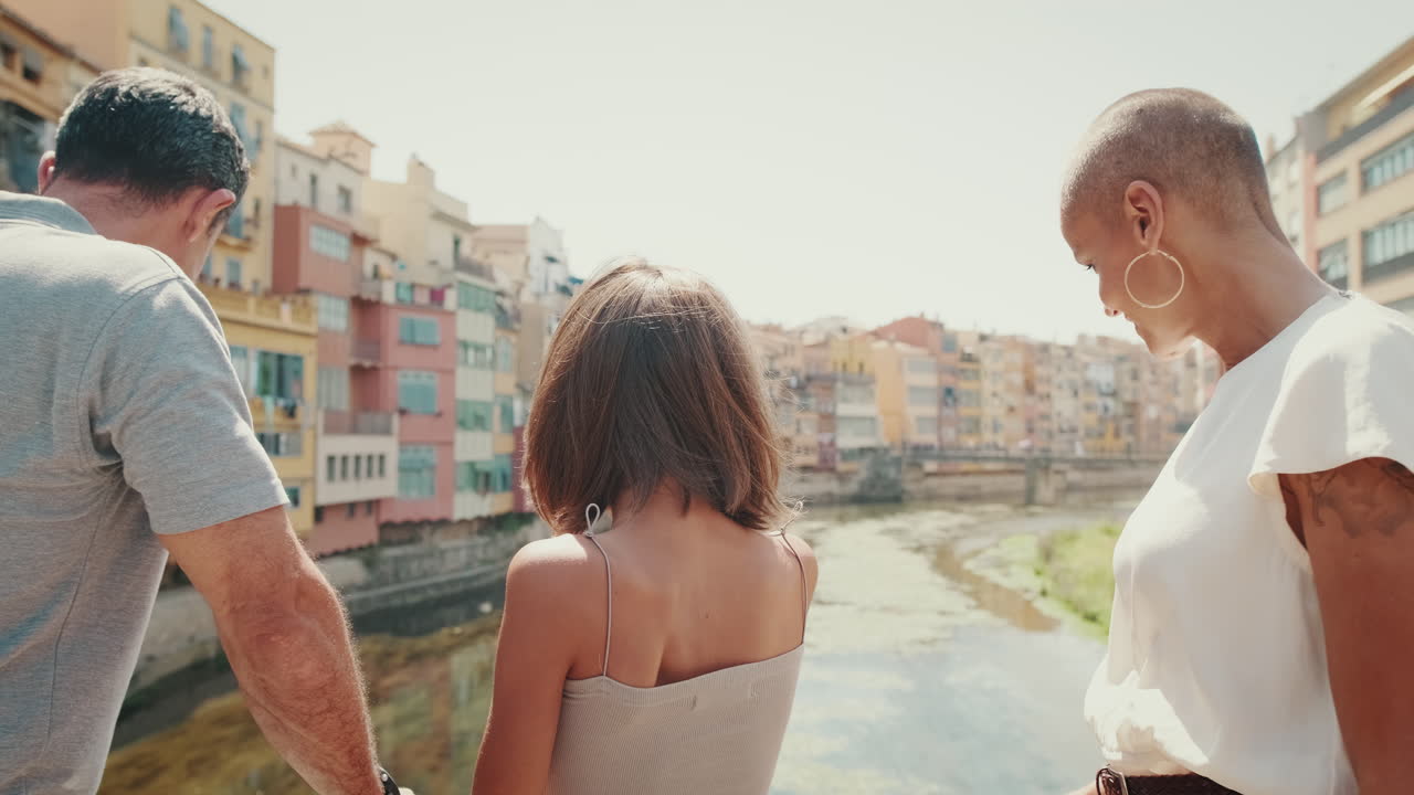 Famiglia che guarda il panorama della città da un ponte in una giornata di sole