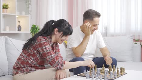 la mujer vence a su marido en una partida de ajedrez. una pareja feliz.
