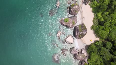 Deslizándose-En-Medio-Del-Reluciente-Mar-Turquesa,-La-Pequeña-Playa-De-Piedras-Gigantes-Y-La-Selva-Tropical-Atlántica-En-Angra-Dos-Reis,-Río-De-Janeiro,-Brasil