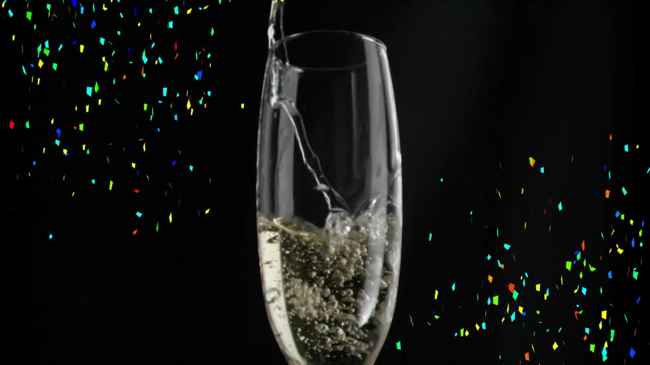 검은색 배경에 다채로운 콘페티 애니메이션으로 페인을 유리잔에 부어 넣는 것