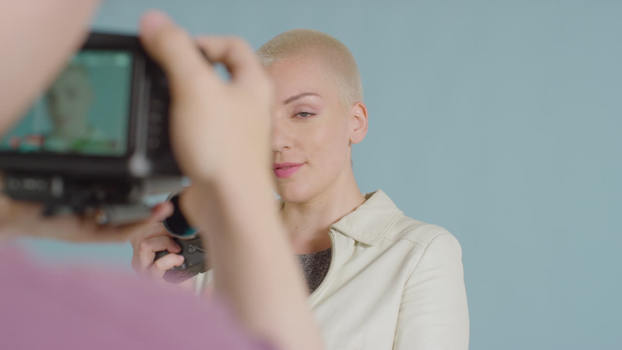 dslr로 포즈를 취한 백인 여성 사진작가의 방탄소년단 영상