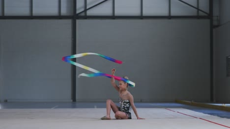 teenage female gymnast performing at sports hall