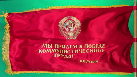 red soviet parade flag flies from flag pole with green screen background for compositing