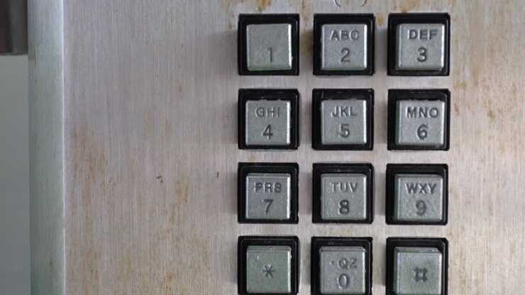 Closeup of public phone buttons. The subject is on the right.