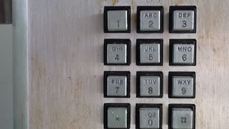 closeup of public phone buttons. the subject is on the right.