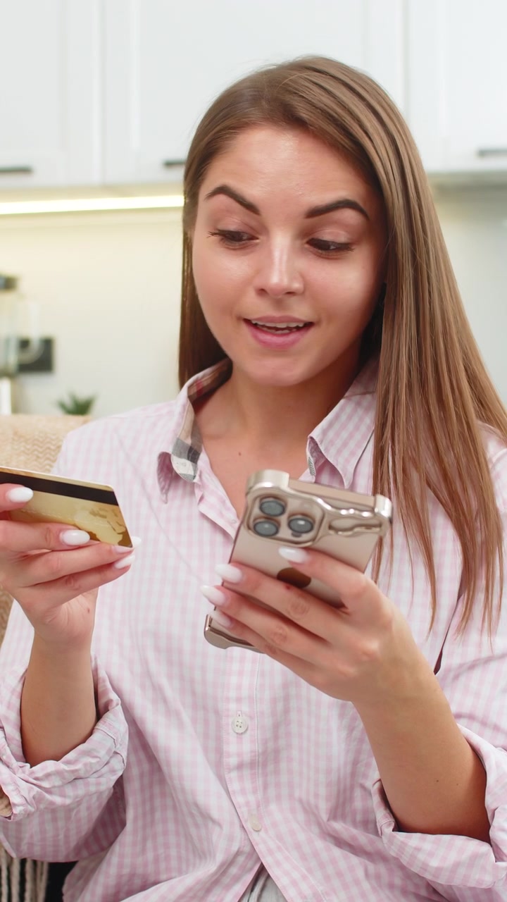 Giovane donna paga un ordine online con smartphone e carta di credito, tocca "paga" e sorride dopo l'acquisto sicuro