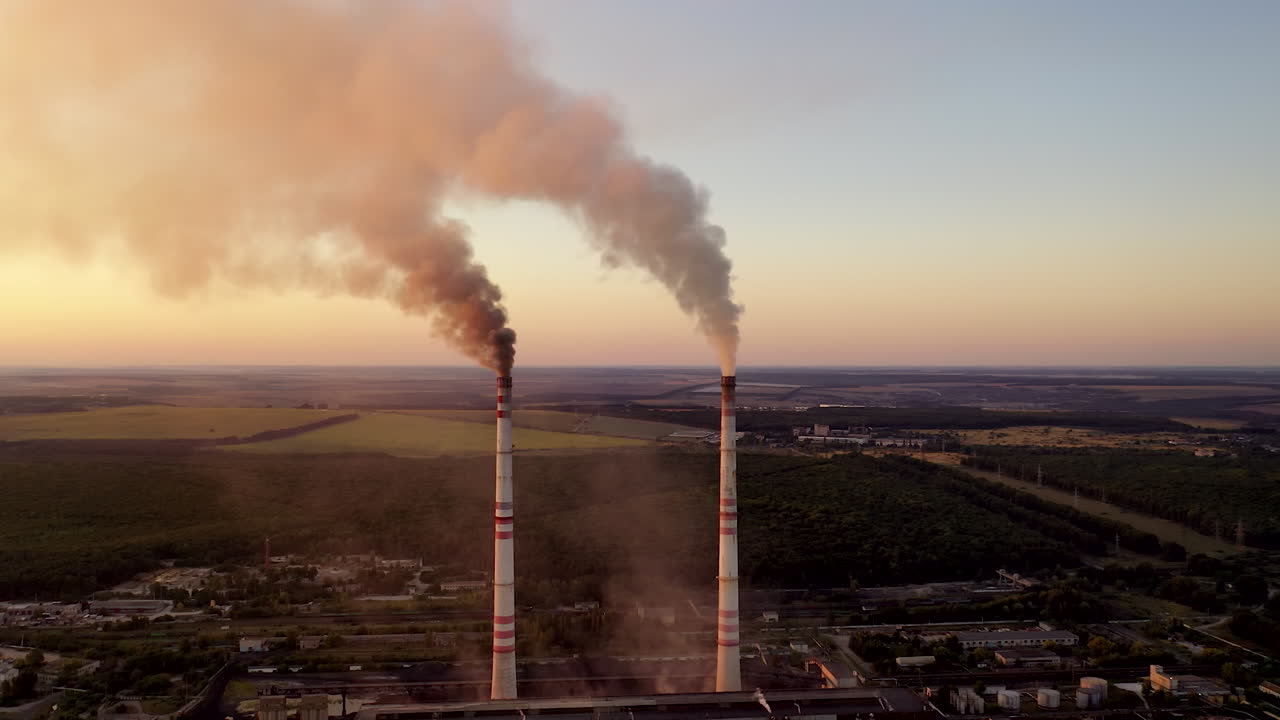 Industrial pipes with smoke in the evening. Toxic emissions from power plant filling the atmosphere. Environmental problems. Global warming.