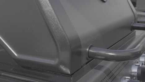close-up of a black barbecue grill being opened or closed