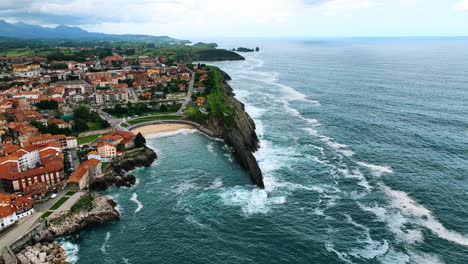 The-drone-is-flying-towards-a-beach-with-a-beautiful-coastline-and-mountains-in-the-background-in-Bilboa-Spain-Aerial-Footage-4K