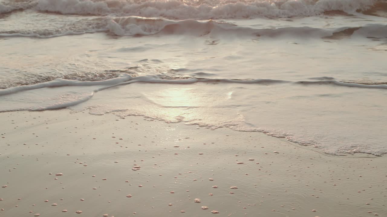 soft waves and foam gliding over quiet beach shoreline