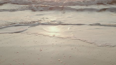 soft waves and foam gliding over quiet beach shoreline