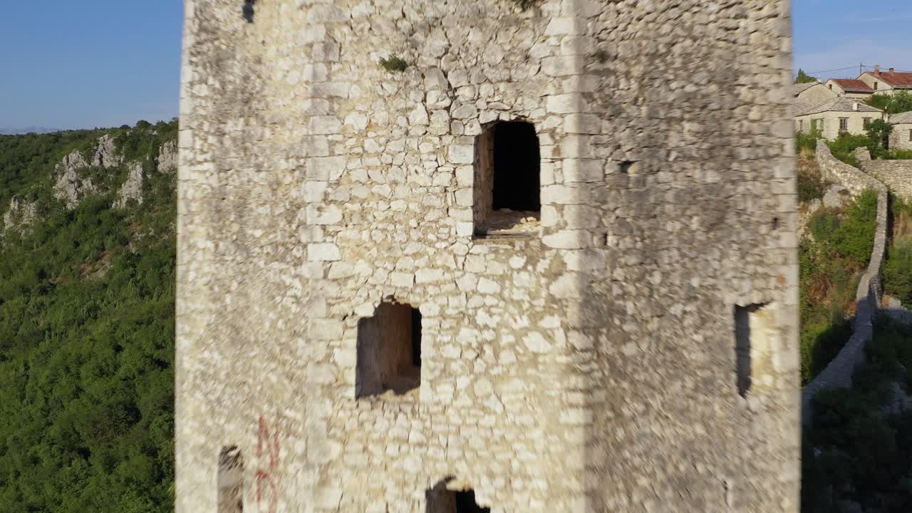 High aerial exhilarating fast drone toward Pocitelj Tower and extremely close to open window