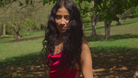 a young latina girl twirls around in her red dress, enjoying the tropical caribbean park