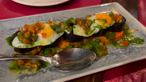 Traditional-Spanish-blood-sausage-with-vegetables-and-quail-eggs-at-a-tapa-restaurant,-tapas-in-Marbella-Spain,-starter-food,-4K-shot