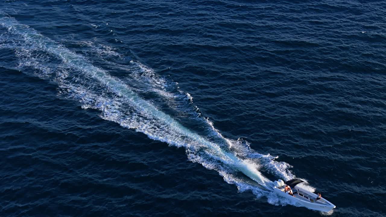 Peschereccio che lascia una grande scia di schiuma bianca mentre naviga nell'oceano aperto.