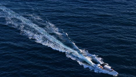 fishing boat leaves large wake white wash as it drives across open ocean