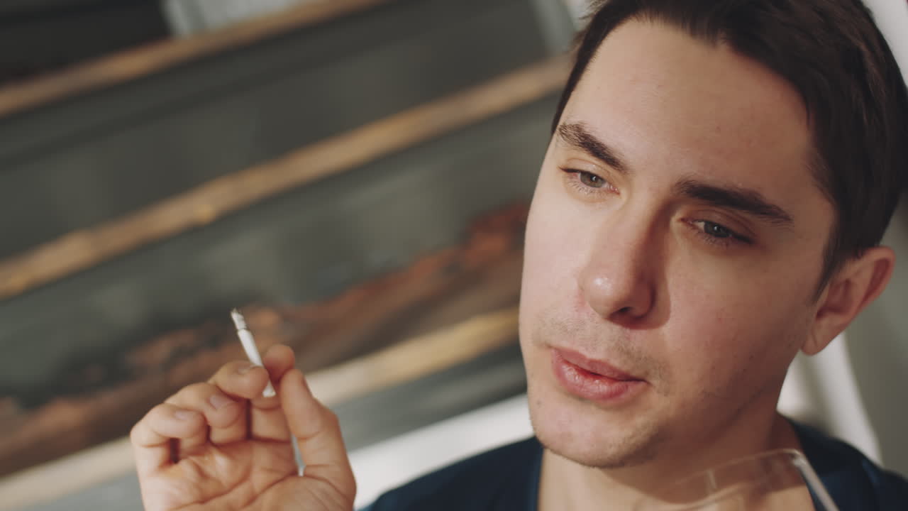 retrato de un hombre transgénero fumando y bebiendo en casa