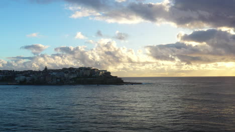 drone volando sobre bondi hacia un barco en el horizonte durante un hermoso amanecer