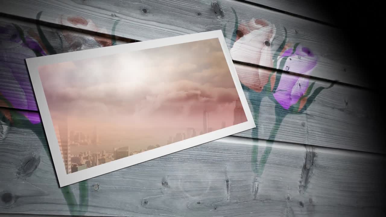 Animation of tablet with cityscape over flowers on wooden boards