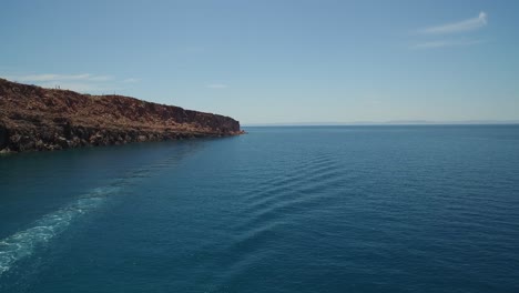 Toma-Aérea-De-Un-Barco-Que-Pasa-Por-La-Isla-Spirit-Santo,-Parque-Nacional-Archipiélago-Spirit-Santo,-Baja-California-Sur