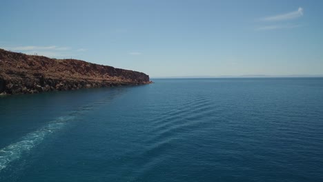 aerial shot of a boat passing by in espiritu santo island, archipielago espiritu santo national park, baja california sur
