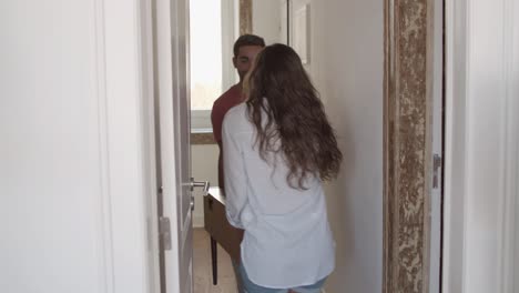 young couple carrying small table into living room together