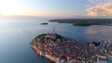 rovinj, croatia aerial pull back shot revealing the town and the harbour at sunset