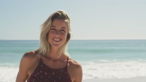 Caucasian-woman-smiling-at-beach-and-looking-at-camera
