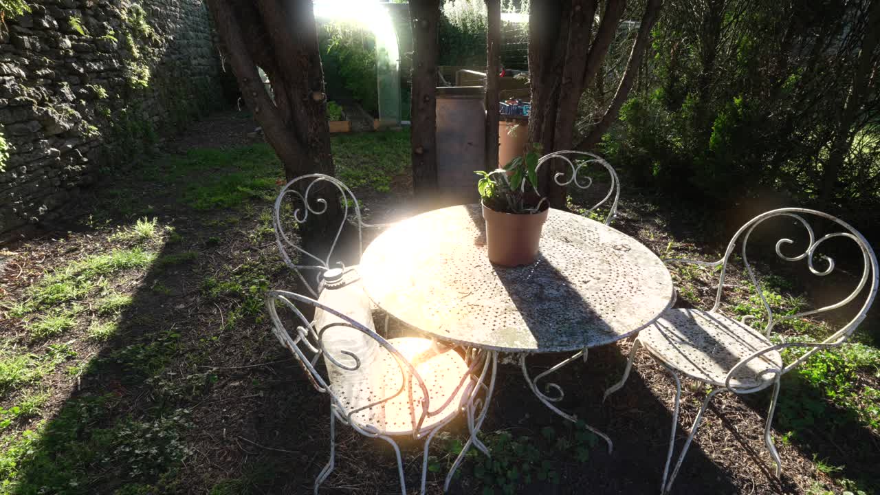 Sunlight on outdoor garden steel furniture set table and chairs, back garden