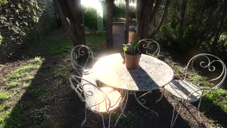 sunlight on outdoor garden steel furniture set table and chairs, back garden