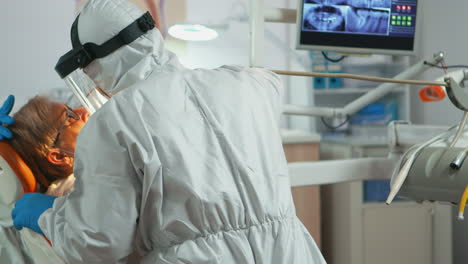 close up of dentistry doctor in coverall using drilling machine