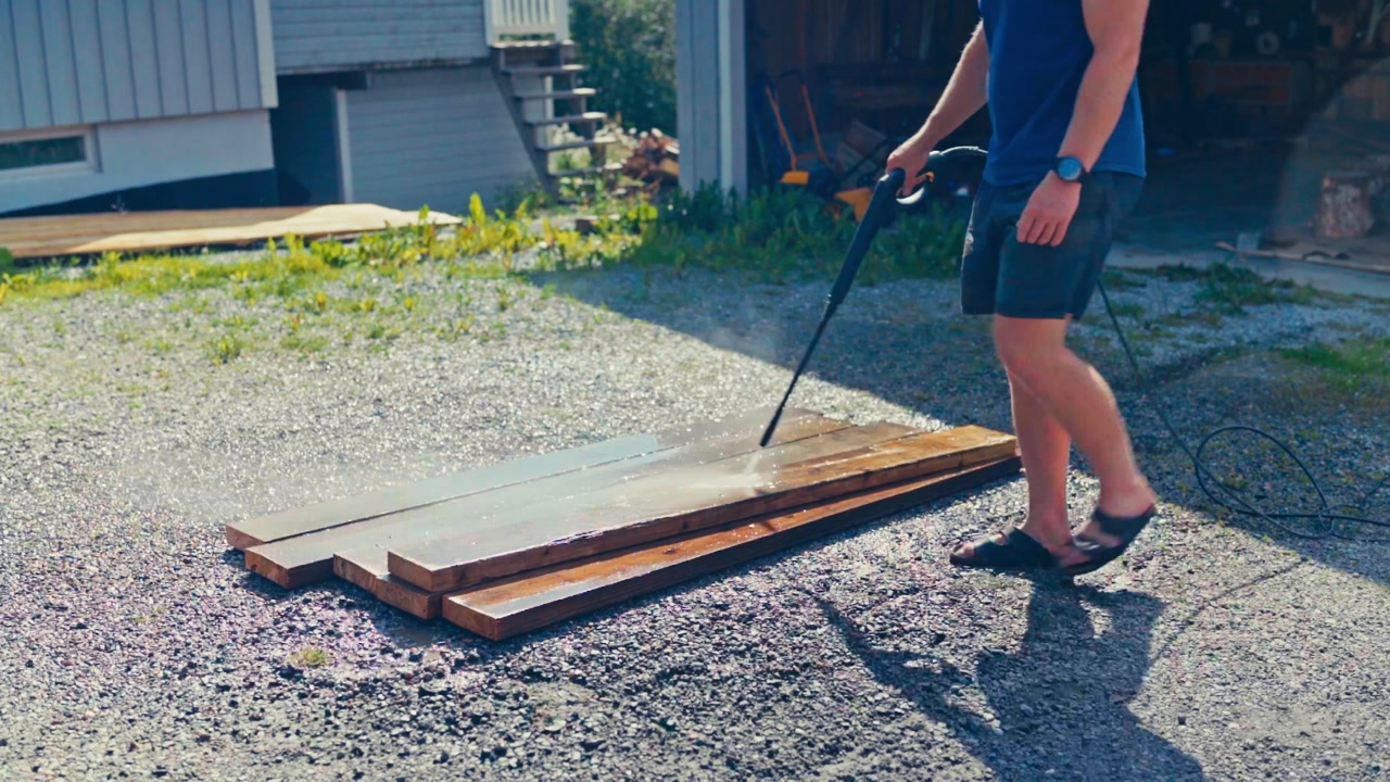 Man Washing Wood Planks With Power Sprayer Hose - Timelapse